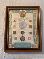 Front view of the framed display showing the Canadian coinage of George V with coins and decorative border.