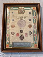Framed display showing selected Canadian coinage of Queen Victoria from 1837-1901, including various coins and stamps with decorative border and central large coin replica.