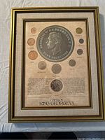 Framed display containing coins from King George VI with large five shillings image and text
