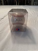 Clear plastic case holding a white baseball signed by Ferguson Jenkins with red stitching and visible signature.