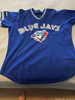 Full front view of blue pullover jersey laid flat