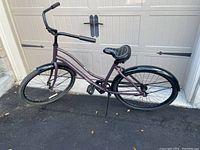 Side profile of purple ladies cruiser bicycle showing step-through frame, fenders, and padded saddle.