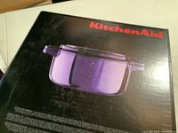 Box front showing purple KitchenAid cast iron casserole pan image and branding.