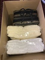Box with two Mansfield Millano pinstripe curtain panel sets in zippered bags and two towel packages