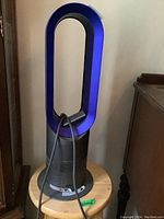 Dyson bladeless fan standing on wooden round bar stool