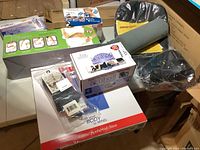 Wide assortment of unopened exercise and wellness products including Pilates Magic Circle, V Shaper, Profile Toner, Easy Shaper, one Sonic Relief pain therapy tool, one Acuball, back and neck supports, two pairs of toe socks.