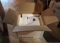 Original Reliable cardboard box opened showing boiler unit and packaging foam