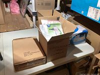 Box of EZ Move furniture mover and unopened box labeled 'Steamers From Works'