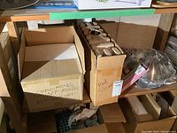 Cardboard boxes labeled 'Stacking Mixing Bowls Kit 3 pcs Set' and 'Food Slicer'. Miscellaneous items on basement shelving.