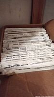 Box filled with approximately 43 mostly Vogue Pattern Service vintage pattern envelopes.
