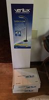 Tall boxed Verilux Sunshine floor lamp box and two smaller Verilux utility tray boxes stacked below.