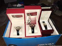 Three Korite watch boxes containing two round watches and one rectangular watch