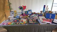 Full display of assorted kids craft supplies arranged on a table including markers, beads, paint, and scissors