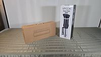 VpCook sous vide cooker and Geryon vacuum sealer boxes on table, unopened.