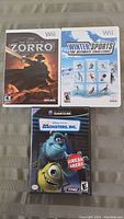 Photo of three video game cases: two Wii games (The Destiny of Zorro and Winter Sports: The Ultimate Challenge) and one GameCube game (Monsters, Inc. Scream Arena edition).