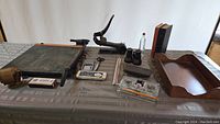 Full lot overview showing paper cutter, stapler, books, ink wells, binoculars, blotter, and other items.