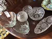All six glass bowls displayed together on a wooden surface showing different shapes and cut designs.