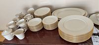 Overview of all service pieces including plates, cups, platters, creamer and sugar bowl