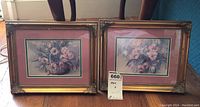 Both framed floral prints together showing size and condition, including small chip on one frame.