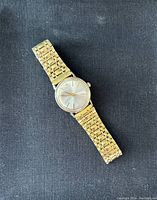 Full front view of watch on black background showing dial and bracelet