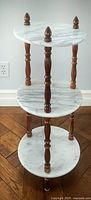 Front view of the 3-tier marble and mahogany display stand showing marble shelving and topped mahogany legs.