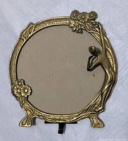 Full front view of the Art Nouveau brass frame showing the round opening, floral decorations, and the female figure detail.