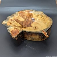 Side angle view of the handmade wood burl bowl showing the natural irregular shape and the dramatic grain pattern with epoxy coating.