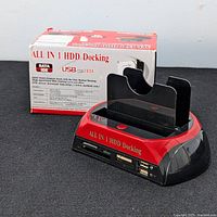 Multi-function HDD docking station with slots for SATA and IDE drives, USB ports, and card reader in black and red finish.
