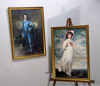 Two large framed prints hung and displayed, Blue Boy on wall and Pinkie on easel, both in gold-tone frames.