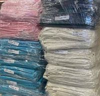 Stacks of variously colored freshly drycleaned table linens wrapped in plastic.