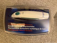 Closed view of Equate Deluxe Digital Ear Thermometer inside translucent plastic case with branding and product information including one second measurement claim.