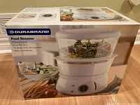 Box of Durabrand Food Steamer showing product image and features including 8 quart capacity, 8 cup rice bowl, 75 minute timer with signal bell, water level indicator.