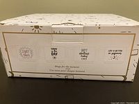 Box showing the four coffee mugs designs with quotes printed on them.