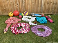 All inflatable toys and balls laid out on grass showing variety and condition.