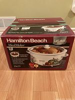 Box of Hamilton Beach MealMaker slow cooker showing brand, model 33675, 6.5 quart capacity, and lid latch strap feature