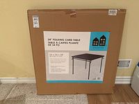 Photo of the sealed box for 34 inch folding card table showing brand Home Collection, size 34x34x28 inches, and product image.