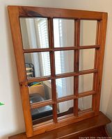 Full view of the wooden framed 12-pane window style mirror showing the rectangular shape and medium stain with visible wood grain.