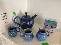 Full lot including teapot, creamer, three mugs, and tea bag house