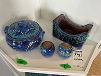 Full set image showing covered bowl, salt and pepper shakers, and caddy on a white shelf