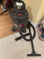 Front view of Shop-Vac QPS30 vacuum with hose attached and floor cleaning attachment on carpet.
