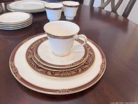 Photo of stacked plates and cups showing detailed design and pattern.