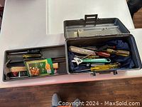 Closed view of tool kit with miscellaneous tools inside two compartments, parts and tools visible