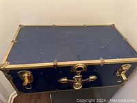 Top view of the blue cedar chest showing gold metal trim and locking hardware with keyhole