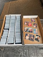 Box containing stacked Marilyn Monroe trading cards, showing the quantity and condition with some examples laid out on the side.