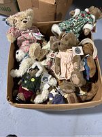 Box filled with various Boyd's Bears in assorted clothing and colors, some with tags visible