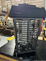Front and side view of black Flowtron bug zapper showing grid cage and UV light tube inside