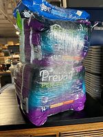 Stack of four packages of Prevail adult pull-on diapers, size XL, wrapped in plastic showing the packaging front and sides.