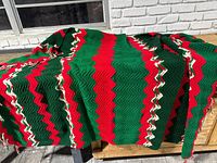 Full view of the crocheted Christmas Afghan blanket laid out showing red, green, and white zigzag stripes