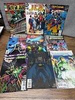 Photo showing all nine comic books arranged on a surface.