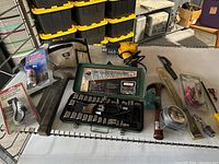 Image showing miscellaneous tools including socket set, hammer, heat gun, and assorted hand tools on table